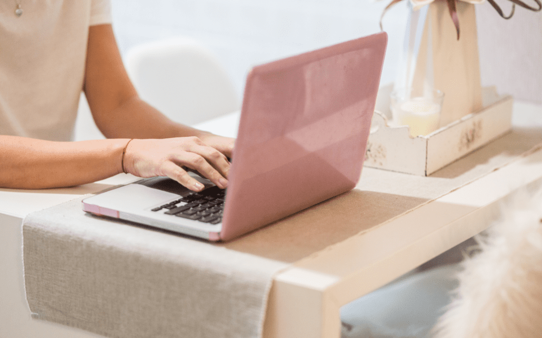 photo of a pink laptop with a woman using it. Woman using it for guided accountability